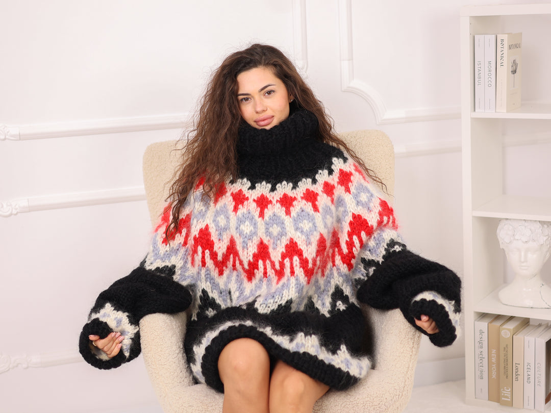 Woman wearing a colorful sweater with a pattern sitting on a chair.