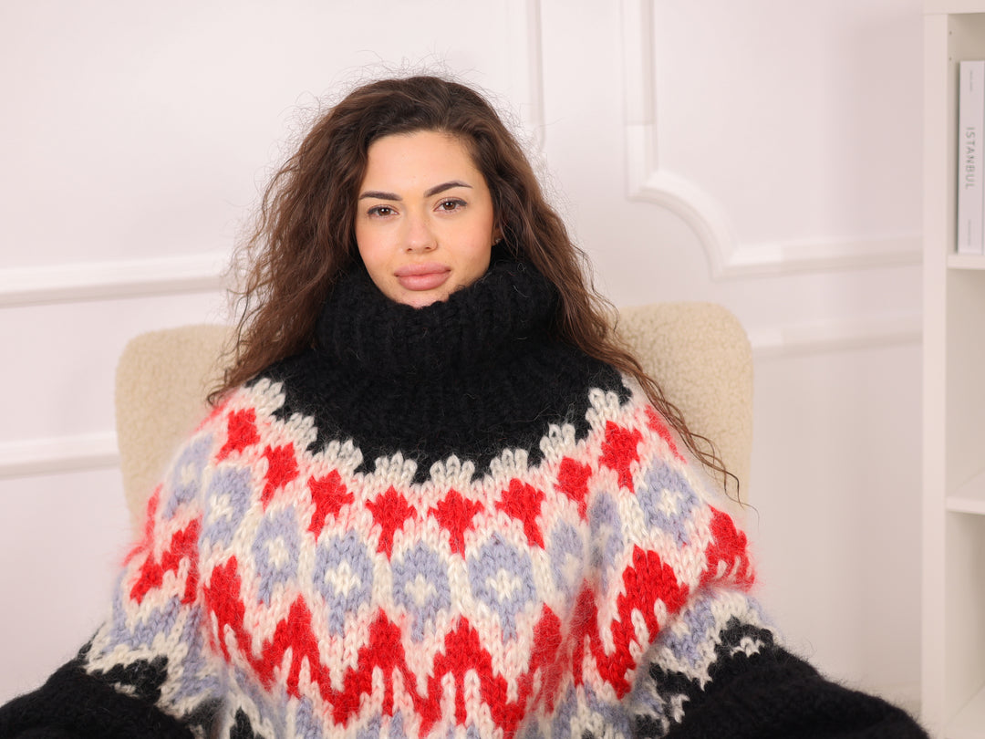 Woman wearing a black turtleneck sweater with a colorful patterned shawl over her shoulders.