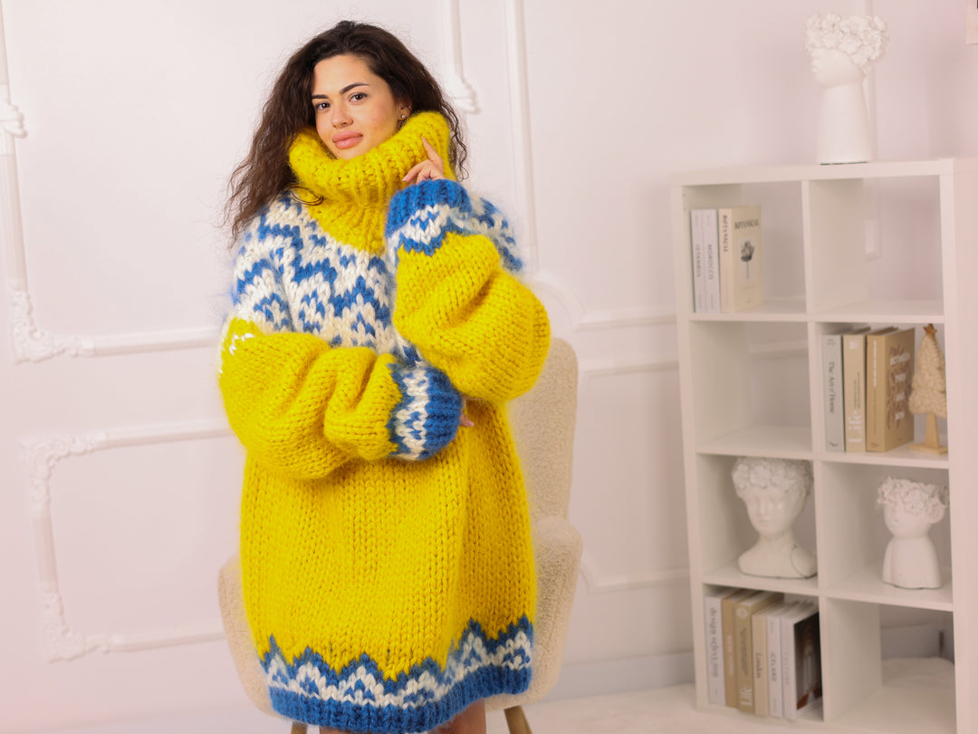 Woman wearing a yellow and blue patterned dress with matching gloves and scarf in a room.