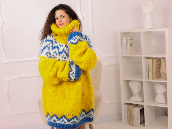 Woman wearing a yellow and blue patterned dress with matching gloves and scarf in a room.