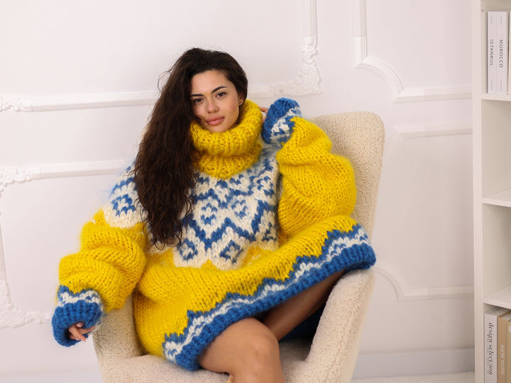 Woman wearing a yellow and blue patterned sweater sitting on a white chair.