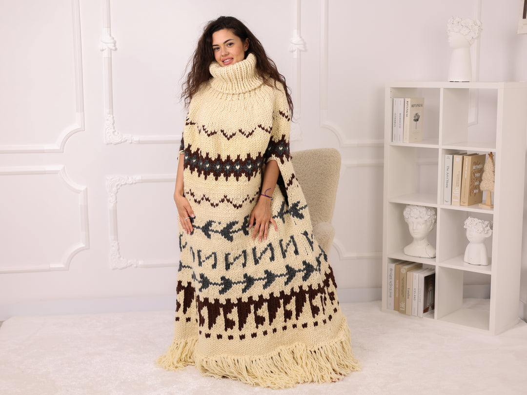Woman wearing a long, patterned dress with turtleneck in a white room.