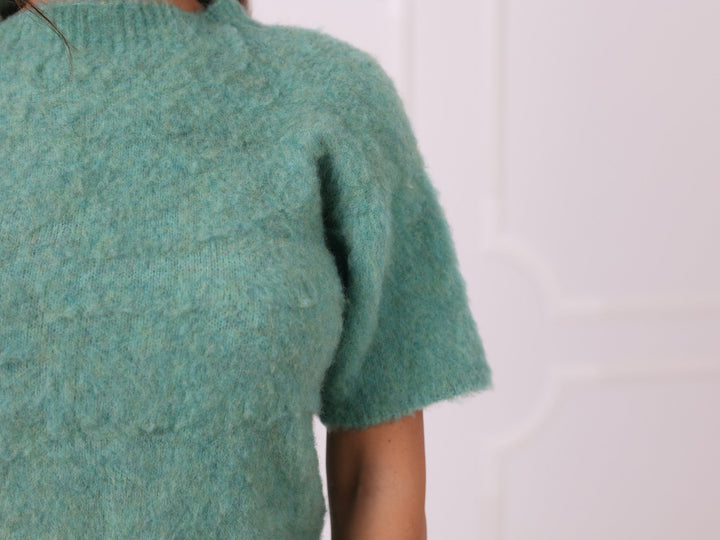 Close-up of soft green yak blend knit texture