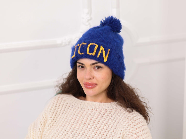 Angled view of blue brushed alpaca personalized pom pom beanie