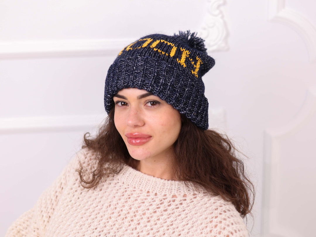 Close up of custom embroidered pom pom beanie on model