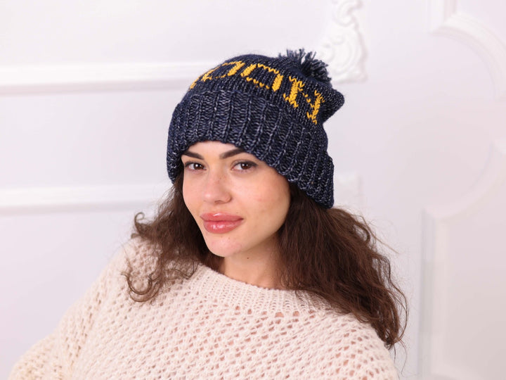 Close up of custom embroidered pom pom beanie on model