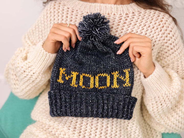 Hand held personalized dark blue cotton wool beanie with pom pom