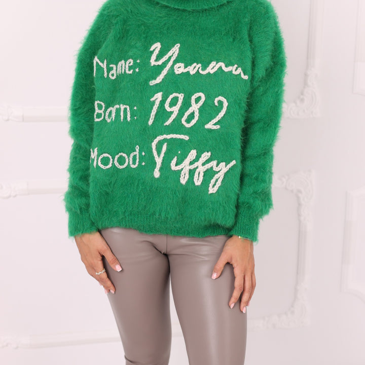 Close up of green alpaca sweater with custom name year and mood embroidery