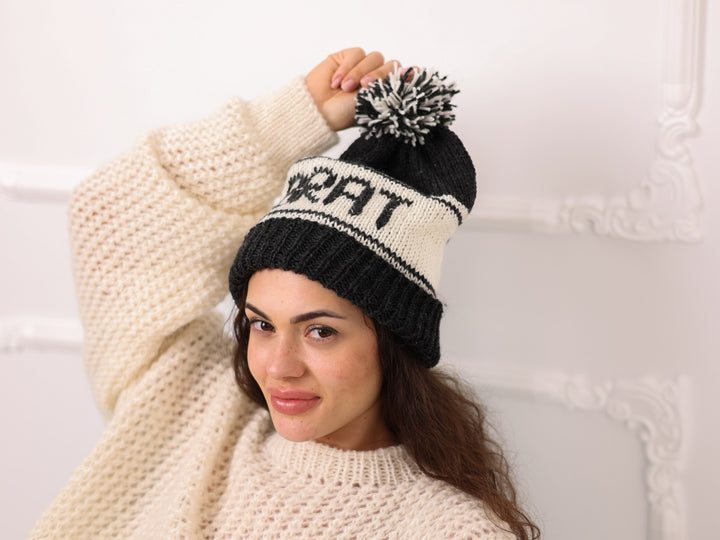 Angled view of black cream soft wool personalized BRAT knit beanie