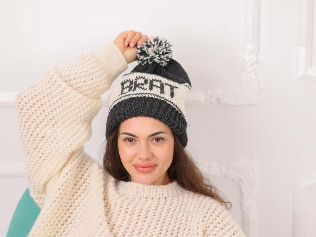 Model wearing black and cream soft wool personalized BRAT beanie