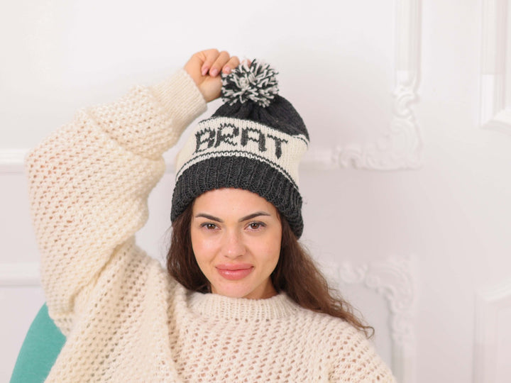 Model wearing black and cream soft wool personalized BRAT beanie