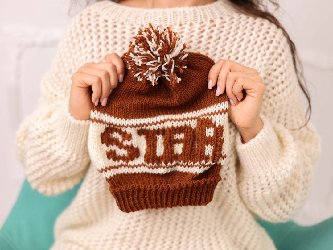Hand held brown and cream soft wool beanie with STAR text and pom pom