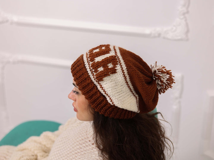 Side view of brown and cream hand knitted STAR beanie with pom pom