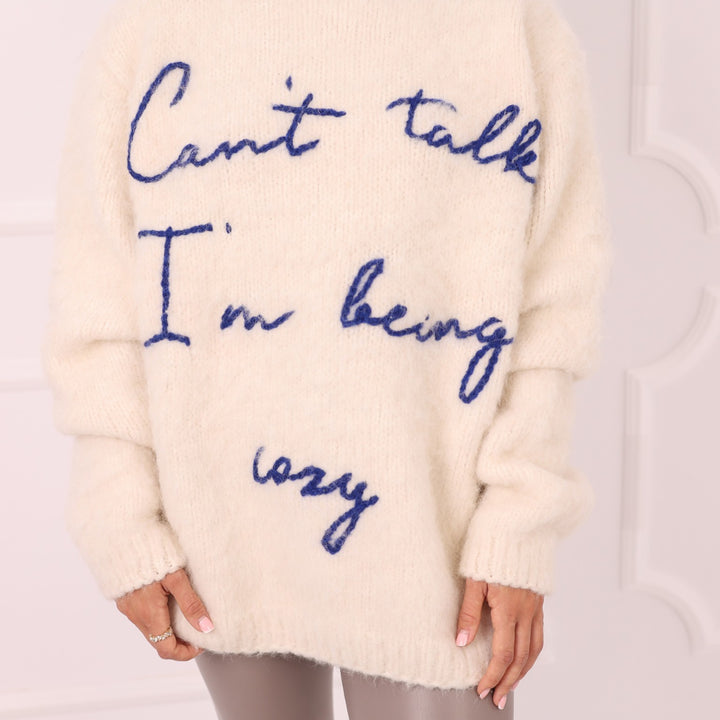 Close up of cream alpaca sweater with blue embroidered personalized text