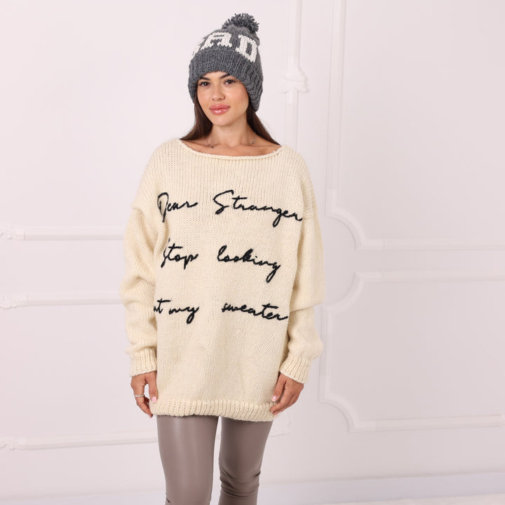Model wearing personalized cream wool sweater with black text