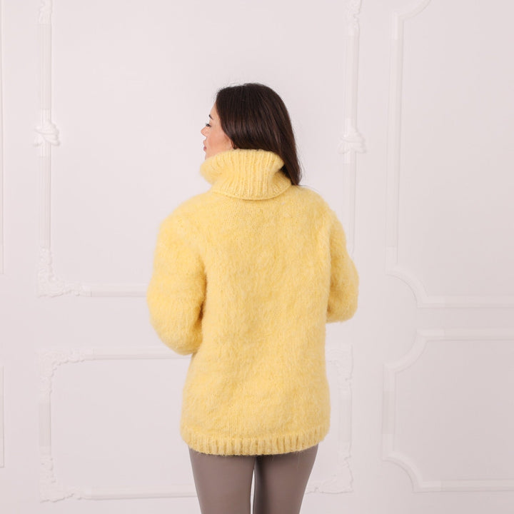 Back view of handmade yellow alpaca oversized sweater with high neck