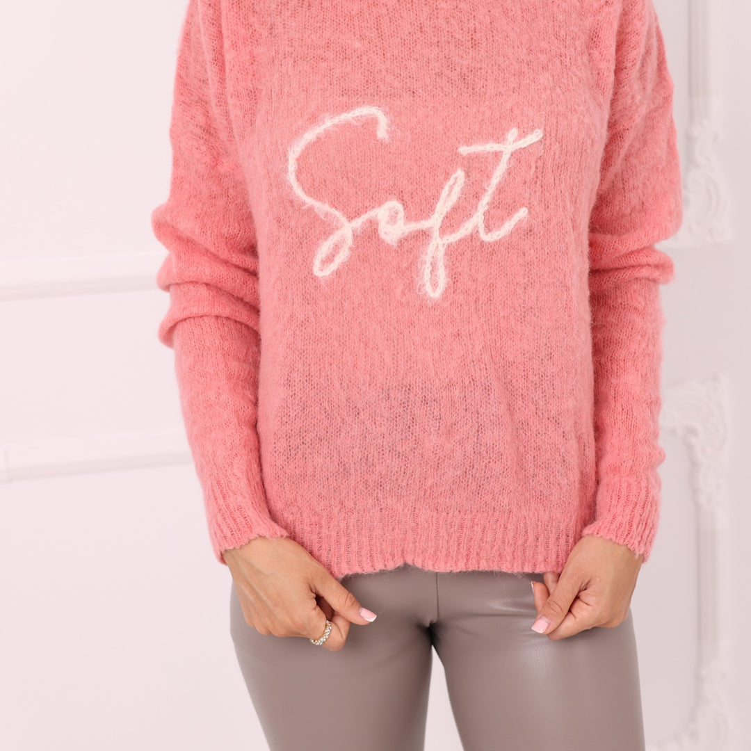 Close up of pink baby alpaca sweater with white embroidered front word Soft