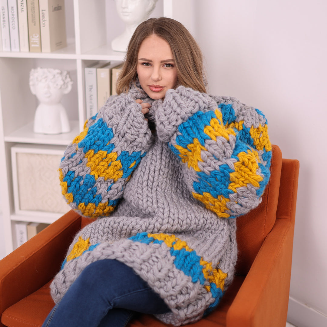 Grey blue mustard chunky wool Nordic sweater seated close view T2402